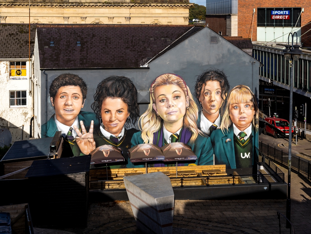 Mural dedicated to the famous award-winning series 'Derry Girls' on Orchard Street, in the city center of Derry, Northern Ireland. Photo credit: Alex Mastro, Shutterstock